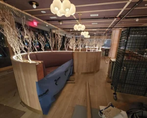 Close-up of sandblasted manzanita branches used as decorative booth dividers with soft lighting in upscale restaurant interior design